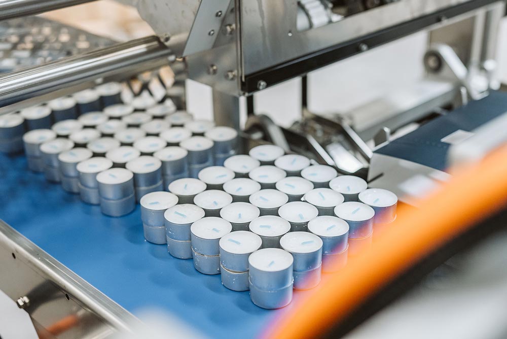 Värmeljus på ett transportband